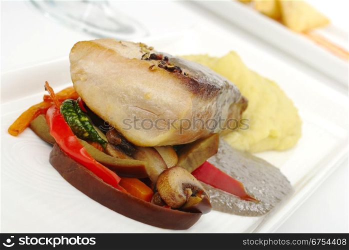 Main Dish: Tuna with mashed potato, gravy and vegetables on white plate with appetizer and glass in the background (Selective Focus, Focus on front part of the fish and some of the vegetable). Main Dish: Tuna with Mashed Potatoes