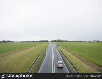 main road N46 north of groningen city between green meadows in the north of the netherlands