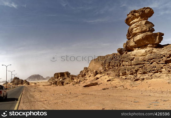 Main road south of the Wadi Rum Nature Reserve, Jordan, with impressive rock formations at the roadside