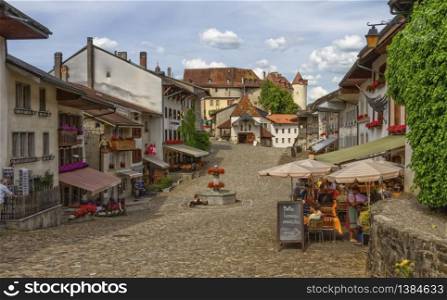 Main street in Gruyere village in Fribourg canton by beautiful day, Switzerland. Gruyere village in Fribourg canton, Switzerland
