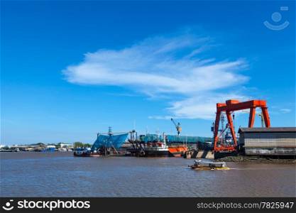 Maintenance of large cargo ship. Located next to the river. A large cargo ship in the sea.
