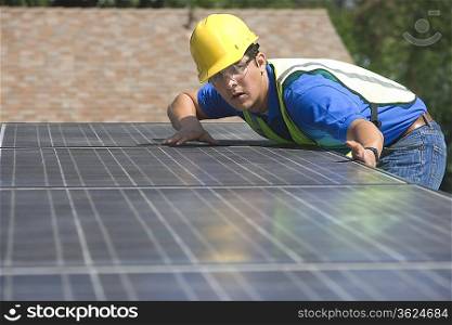 Maintenance worker measures solar array on rooftop Los Angeles California