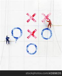 Maintenance workers play tick-tack-toe outside a wall