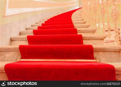 Majestic interior marble stairs from a luxury building covered with red carpet