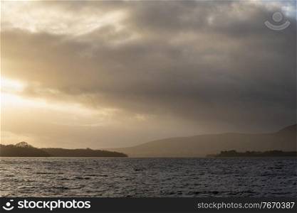 Majestic landscape image of Milarrochy Bay on Loch Lomond in Scottish Highlands with stunning Winter evening ligh