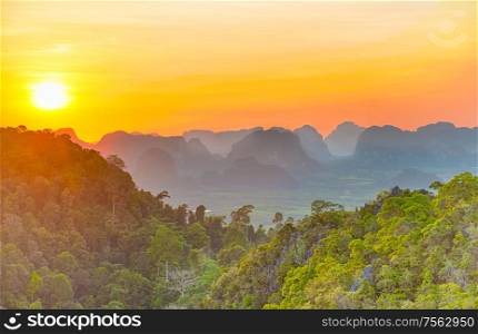 Majestic landscape with dramatic sunset and silhouette of steep mountain ridge on horizon. HDR image