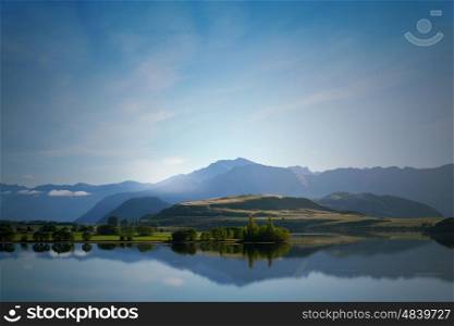 Majestic mountain lake. Beautiful natural landscape of mountain lake and field