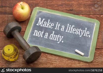 Make it a lifestyle, not a duty - fitness and healthy life concept - slate blackboard sign against weathered red painted barn wood with a dumbbell, apple and tape measure