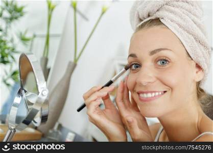 make-up artist applying the mascara to model close up