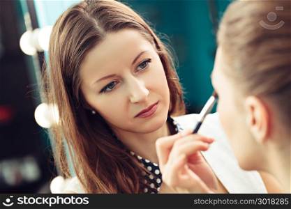 Make-up artist at work applying eyeshadows
