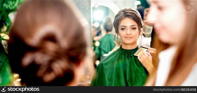 Make-up artist doing makeup for young beautiful bride applying wedding makeup in a beauty salon. Make-up artist doing makeup for young beautiful bride applying wedding makeup in a beauty salon.