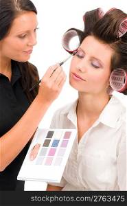Make-up artist woman fashion model apply eyeshadow from color palette