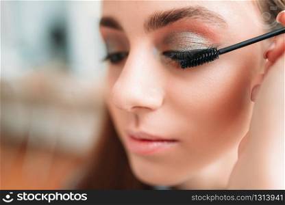 Make up artist work with woman eyes, beauty studio on background. Cosmetic salon. Make up artist work with woman eyes