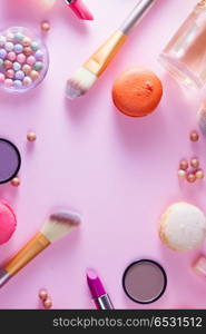 Make up products and macaroons. Make up products and macaroons close up flat lay scene on pink background