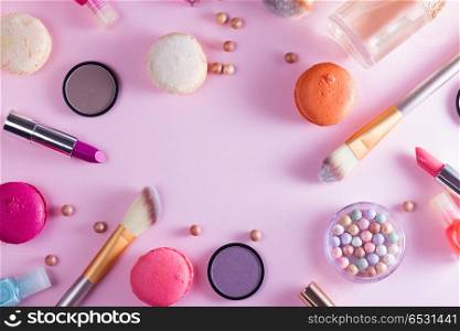 Make up products and macaroons. Make up products and macaroons frame on pink background