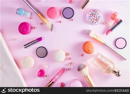 Make up products and macaroons. Make up products and macaroons on pink background flat lay scene