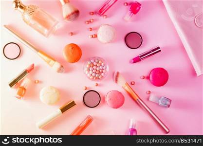 Make up products and macaroons on pink background, toned. Make up products and macaroons. Make up products and macaroons