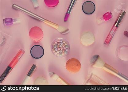 Make up products and macaroons pattern on pink background, retro toned. Make up products and macaroons. Make up products and macaroons