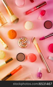 Make up products and macaroons pattern on pink background, toned. Make up products and macaroons. Make up products and macaroons