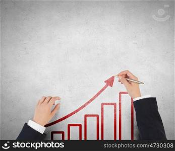 Make your income grow. Businessman hands drawing with pen increasing arrow over concrete background