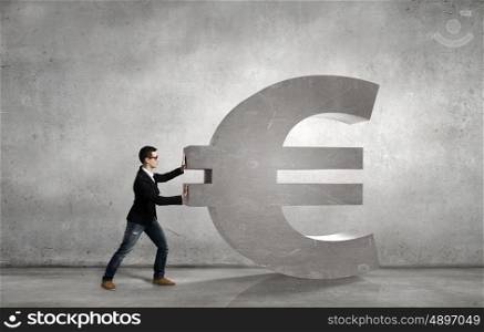 Make your income grow. Young businessman rolling big stone euro sign