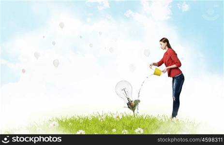 Make your investments grow. Young woman watering sprout with yellow bucket as symbol of income concept
