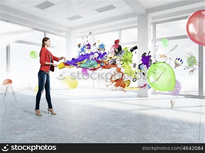 Make your life colorful. Young woman in casual holding yellow bucket with splashes