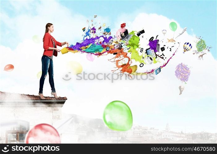 Make your life colorful. Young woman in casual holding yellow bucket with splashes