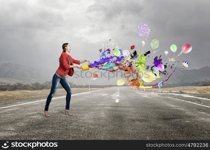 Make your life colorful. Young woman in casual holding yellow bucket with splashes