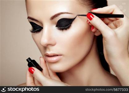 Makeup artist applies eye shadow. Beautiful woman face. Perfect makeup