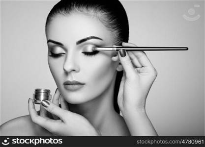 Makeup artist applies eye shadow. Beautiful woman face. Perfect makeup. Makeup detail. Beauty girl with perfect skin. Nails and manicure. Black and White