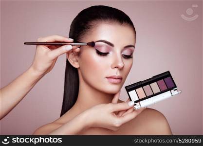Makeup artist applies eye shadow. Makeup Artist applies Eye Shadow. Beautiful Woman Face. Perfect Makeup. Make-up detail. Beauty Girl with Perfect Skin. Nails and Manicure. Eye Shadow Palette