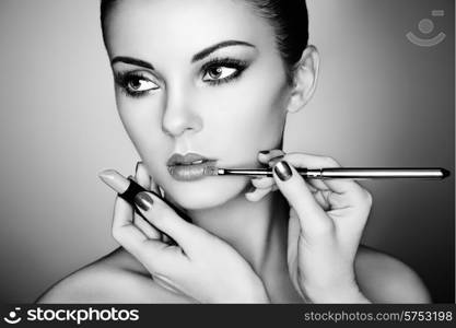 Makeup artist applies lipstick. Beautiful woman face. Perfect makeup. Black and white