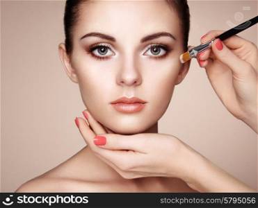 Makeup artist applies skintone. Beautiful woman face. Perfect makeup. Skincare foundation