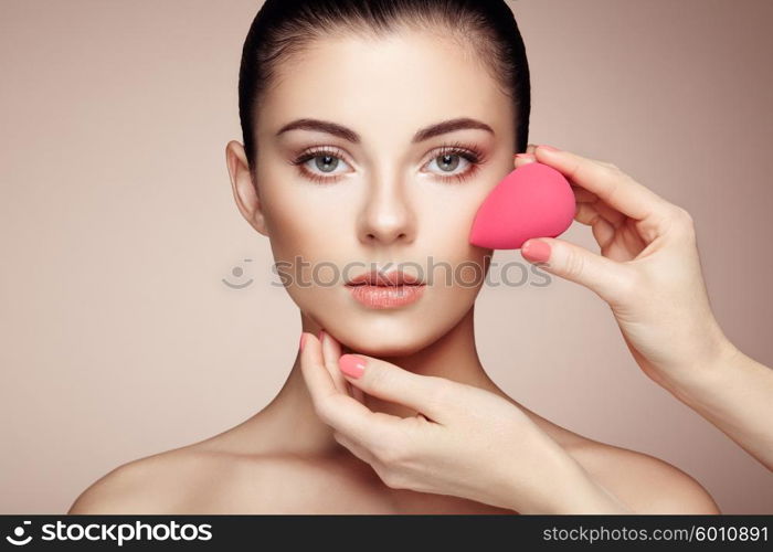 Makeup artist applies skintone. Beautiful woman face. Perfect makeup. Skincare foundation. Sponge makeup artist