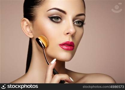 Makeup artist applies skintone with brush. Beautiful woman face. Perfect makeup. Skincare foundation. Brushes makeup artist