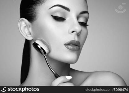 Makeup artist applies skintone with brush. Beautiful woman face. Perfect makeup. Skincare foundation. Makeup artist. Black and White photo