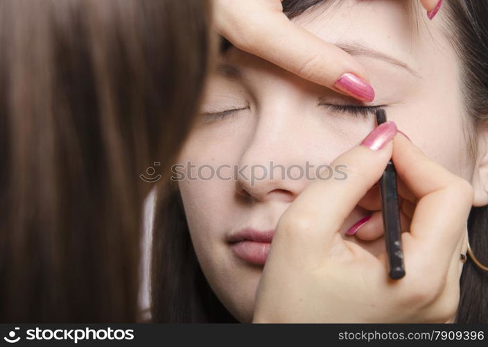 Makeup artist deals makeup on the model&rsquo;s face. She paints eyelashes model.