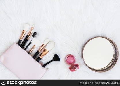 makeup brushes bag with pink compact powder round mirror fur backdrop