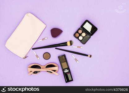 makeup brushes eyeshadow palette sunglasses purple backdrop