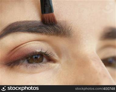 Makeup eyebrows close-up with a soft brush.. Makeup close-up. Eyebrow makeup, soft brush.