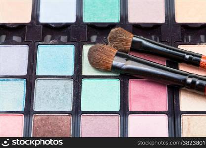 makeup kit and cosmetic brushes close up