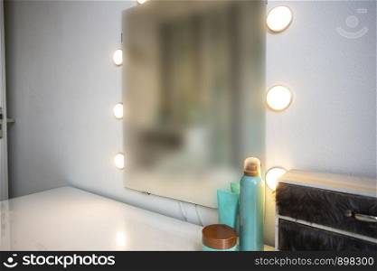 Makeup mirror on table near white wall in dressing room clean and new. Makeup mirror on table near white wall in dressing room
