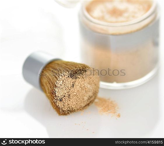 Makeup powder and brush on white background