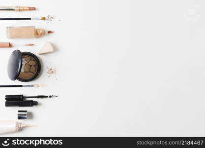 makeup products arranged gray background