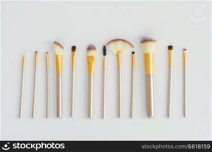 Makeup silver and gold brushes row on white background. Make up brushes