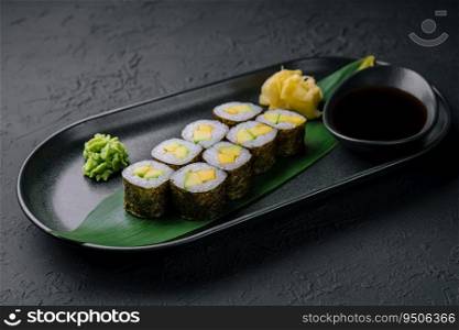 Maki sushi roll with avocado on black plate