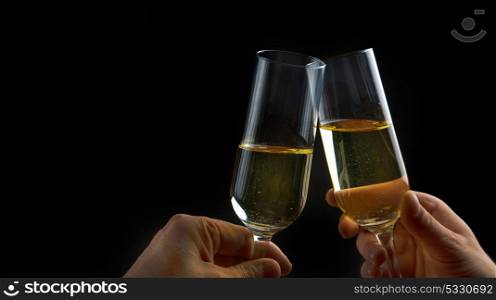 making a toast with champagne glasses in black background