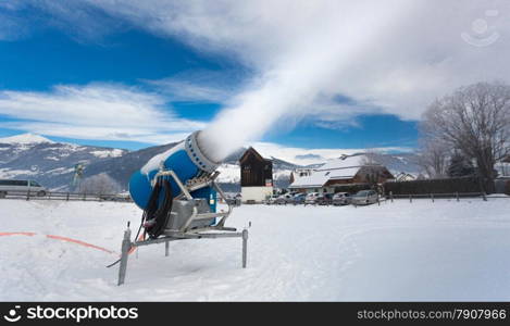 Making artificial snow on ski resort at cold day in Alps