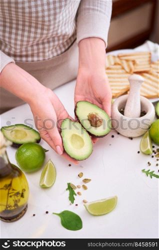 Making avocado toast - Woman hold fresh ripe halved avocado.. Making avocado toast - Woman hold fresh ripe halved avocado
